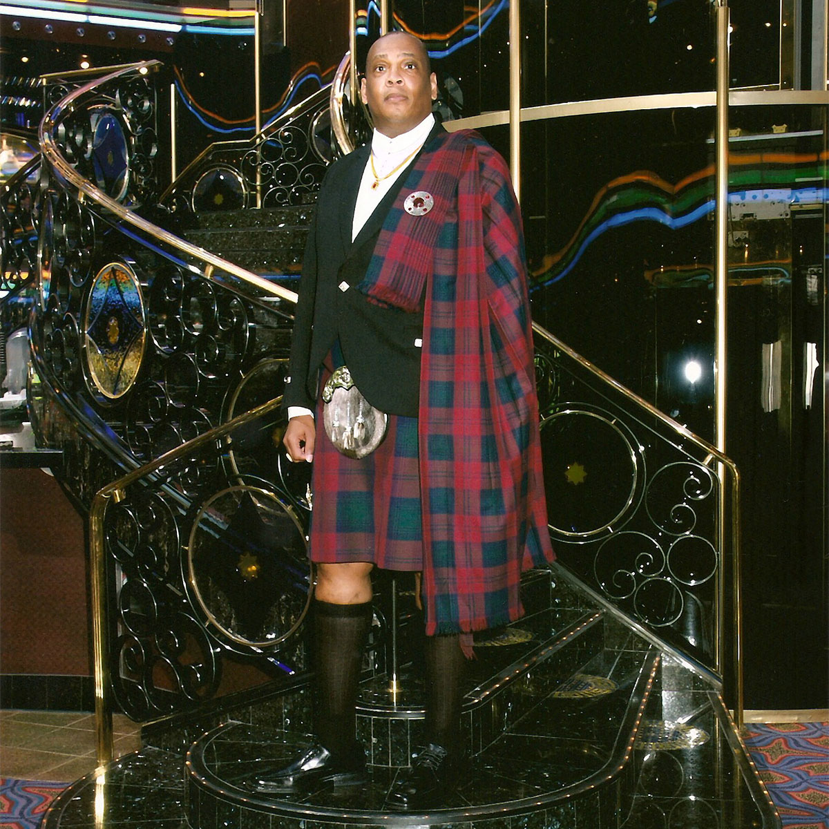 A man in a Homespun Wool Blend Piper's Plaid kilt standing on a staircase.