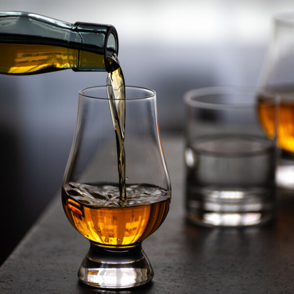 A glass of whisky is being poured into a glass.
