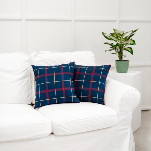 Two plaid throw pillows on a white couch.