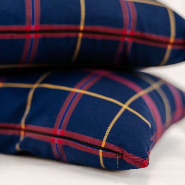 Two blue and yellow plaid pillows on top of each other.